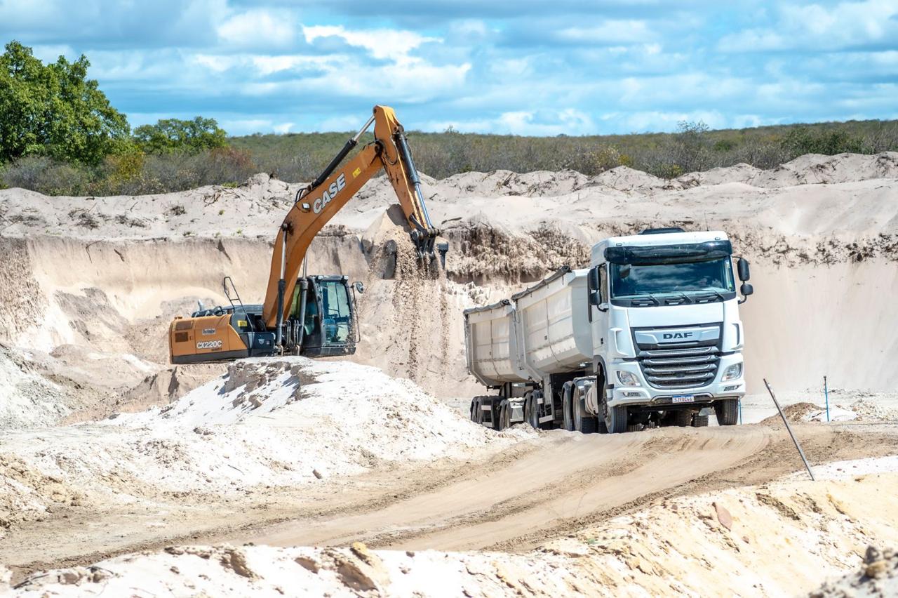 Escavadeira carregando caminhão de areia